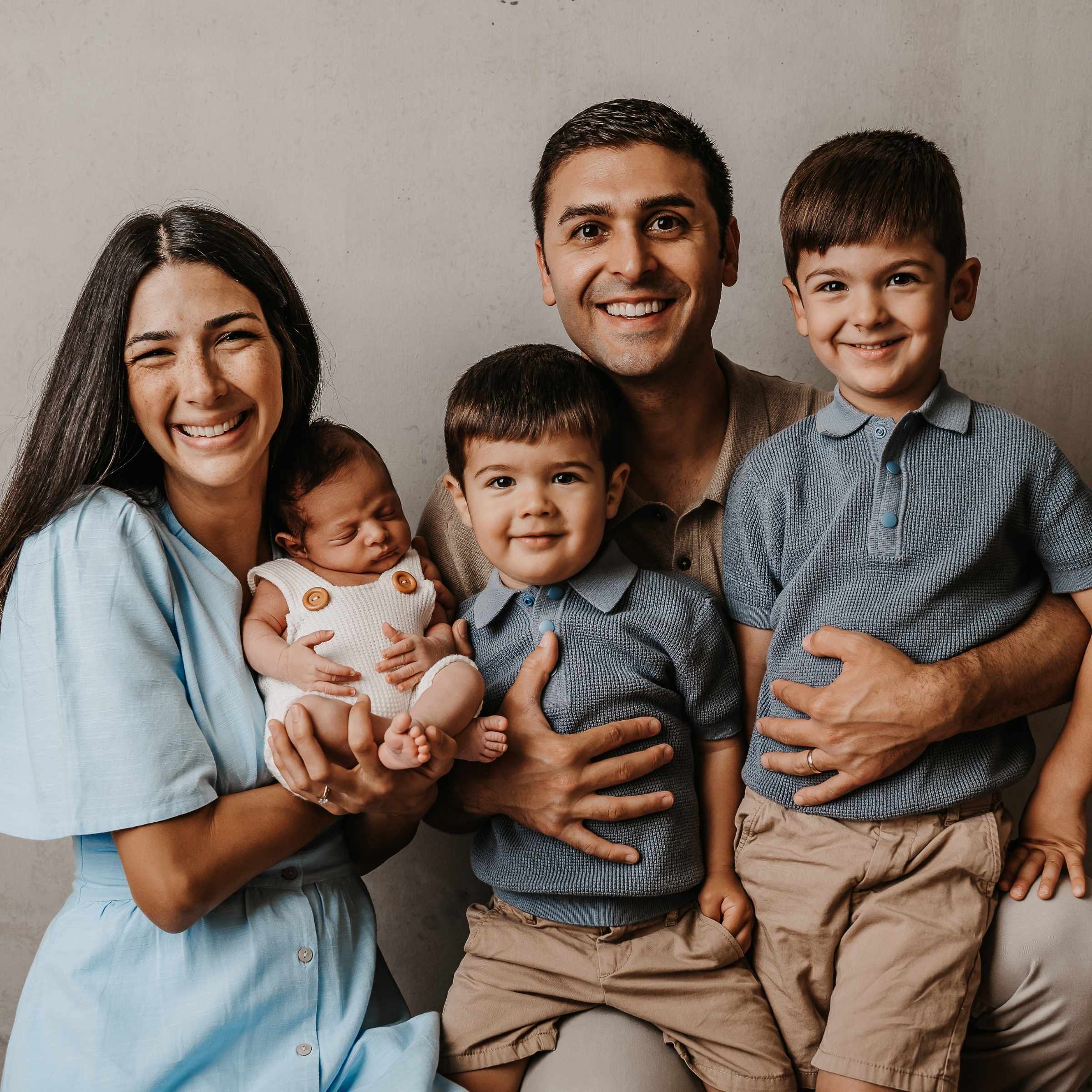 A mother and father with their three young children who are all boys.