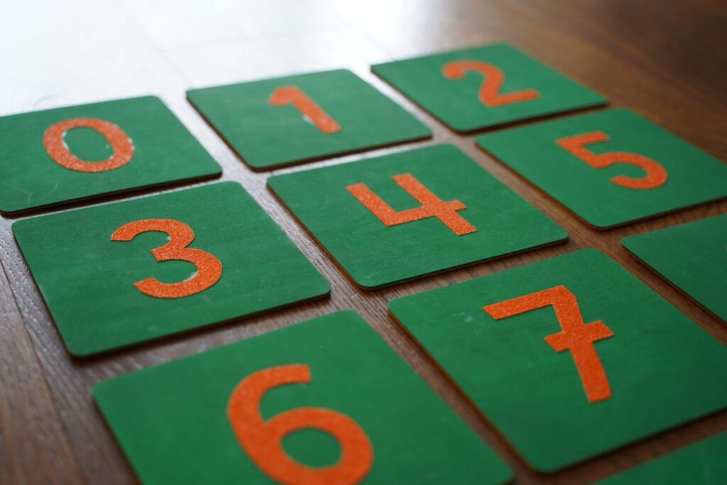 Montessori number cards 0–9 with green boards and orange numerals used for early math and counting activities.