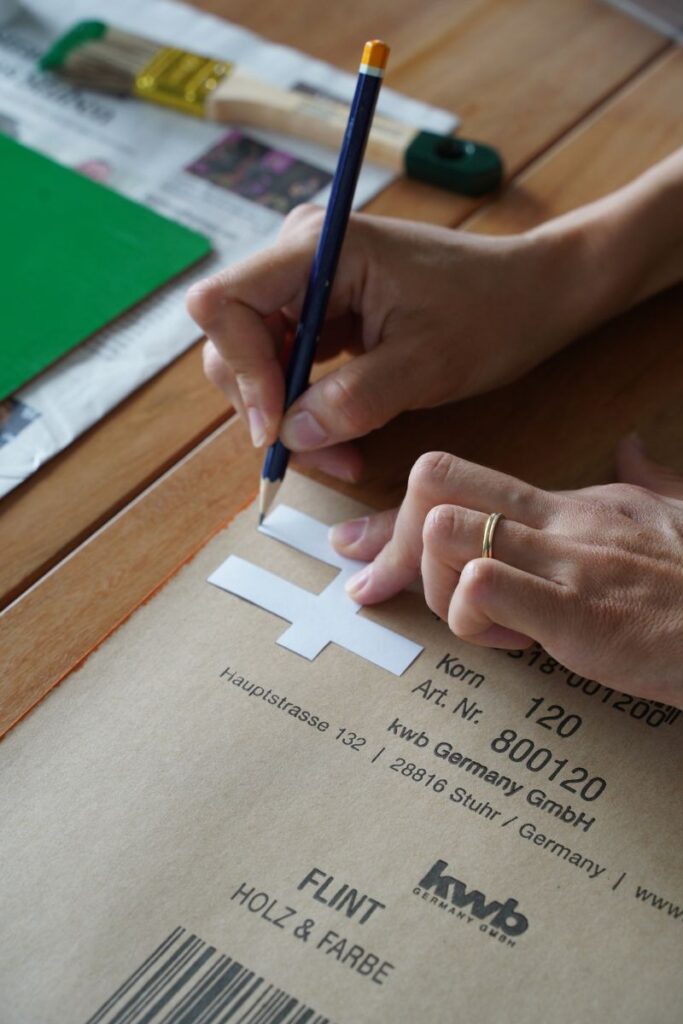 Tracing number 4 template backwards on sandpaper for a DIY Montessori Sandpaper Numbers activity to create tactile math learning materials.