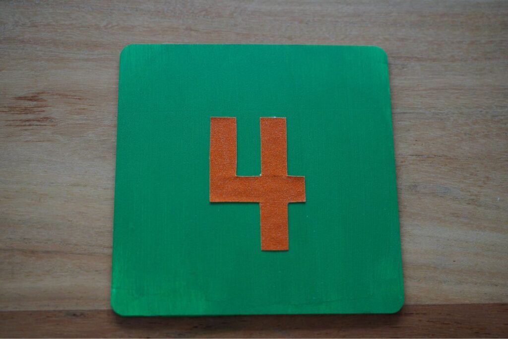 Finished DIY Montessori sandpaper number card with the number 4, used for tactile learning and early math practice.
