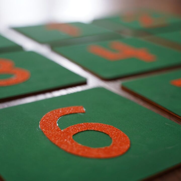 Montessori number cards 0–9 with green boards and orange numerals used for early math and counting activities.