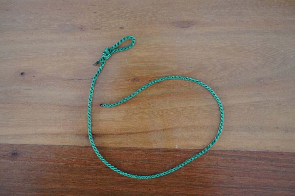 Green Montessori ribbon used for wrapping spindles in the DIY spindle box math activity for counting and number recognition.