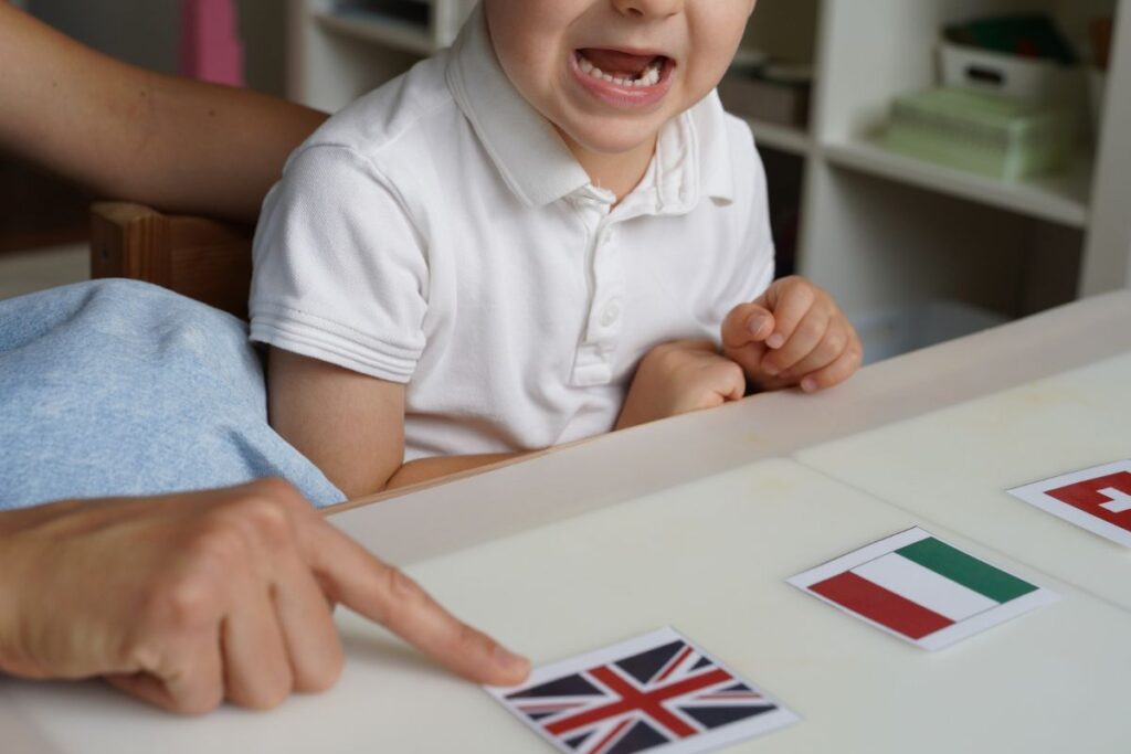 Montessori geography activity: child recalling and identifying the United Kingdom flag with Montessori flag cards.
