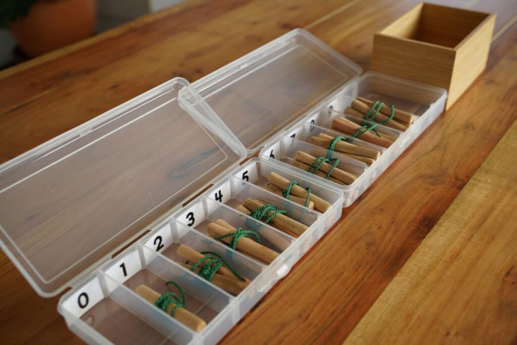 Montessori spindle box material with wooden spindles organized by number compartments for hands-on math and counting practice.