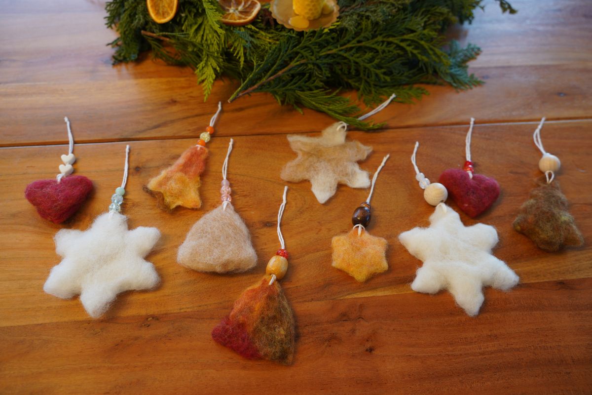 Collection of Montessori-style wet-felted ornaments—hearts, stars, and trees—decorated with beads and natural fibers.